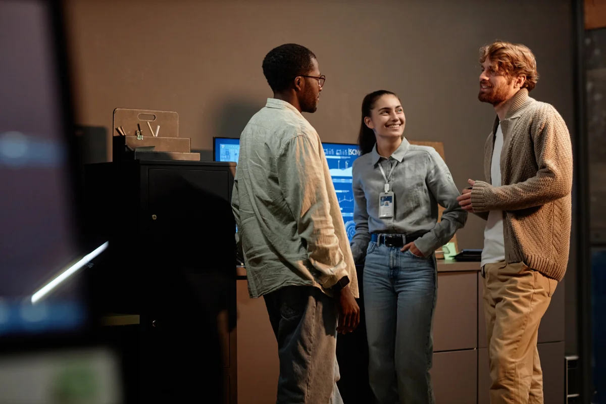 Group of three people standing in office and talking