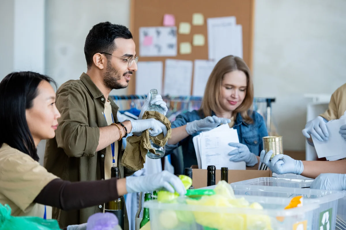 volunteers recycling bottles and cans at workplace
